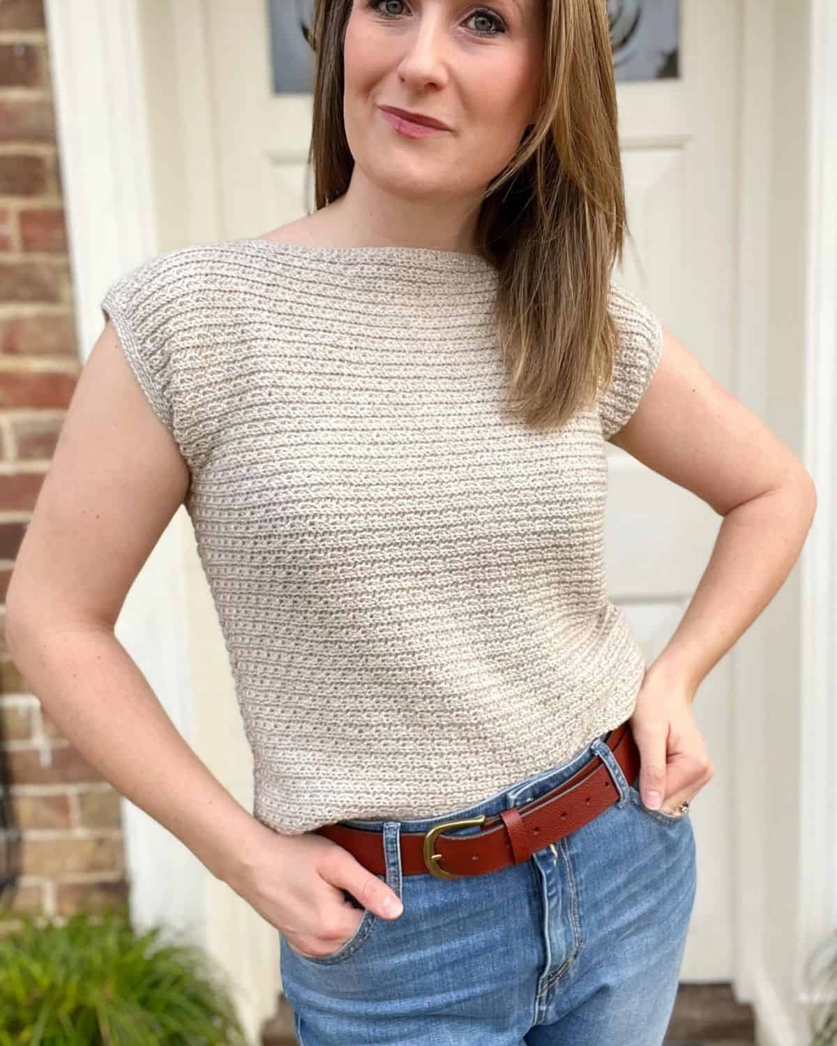 Simple crochet top pattern in cream with short sleeves on a woman.