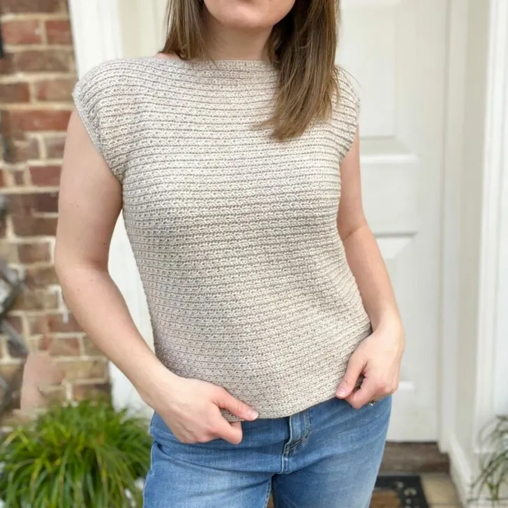 Simple crochet top pattern in cream worn by a woman.