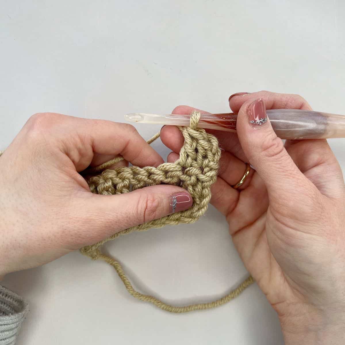 Showing next double crochet stitch after a stacked crochet stitch.