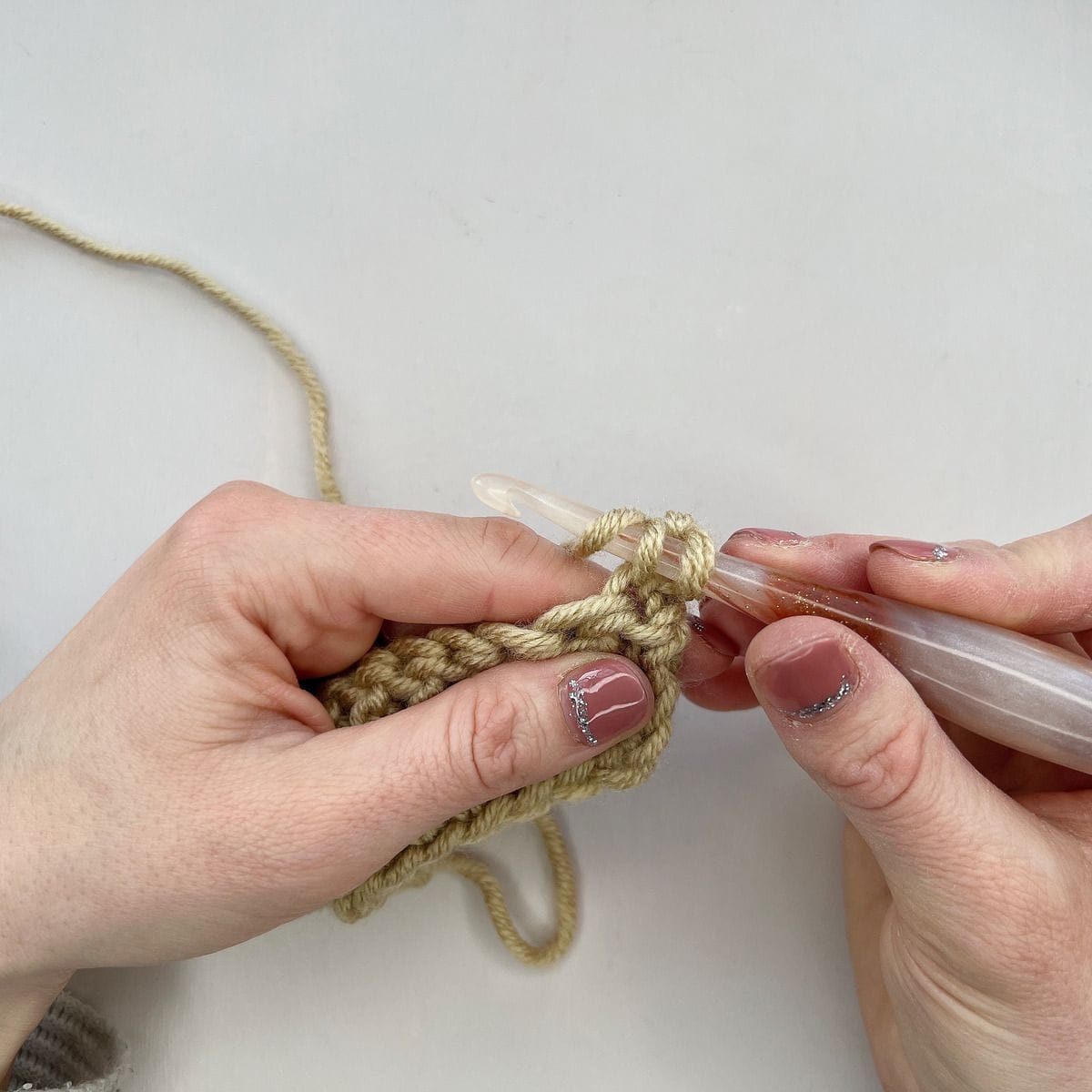 Crochet showing yarn over to work a stitch.