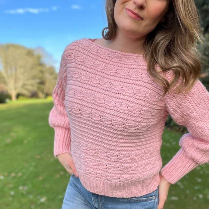 Pink crochet crop sweater pattern with cable details.