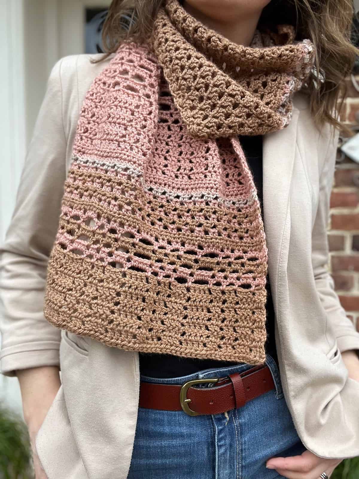 Elegant crochet scarf pattern in color stripes worn by a woman.