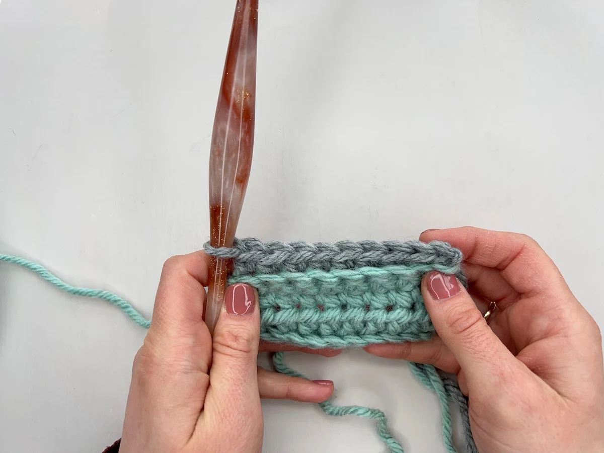 Row of single crochet blo stitches in grey yarn.