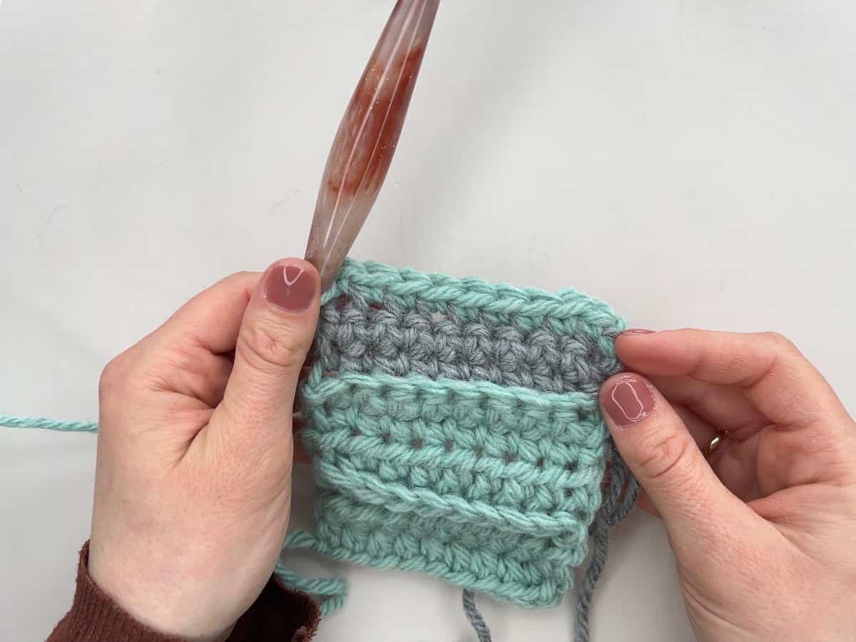 Row of single crochet flo in grey yarn.