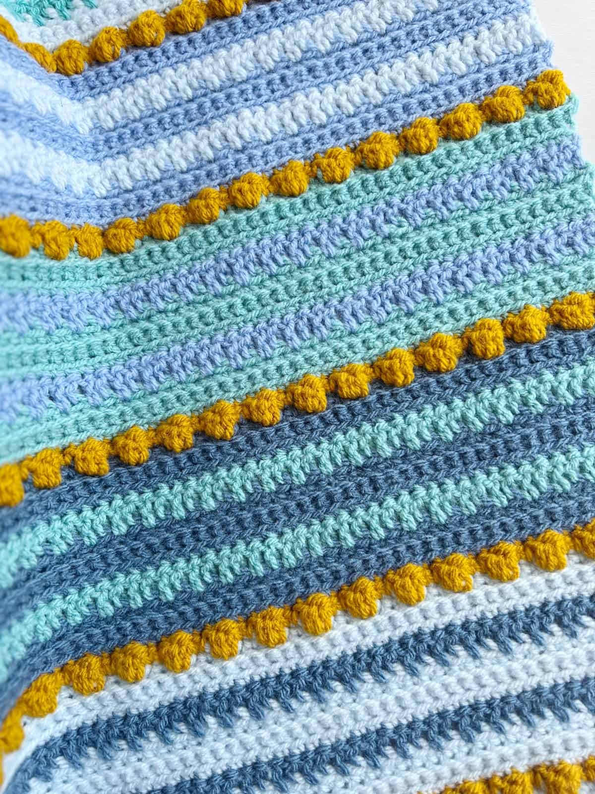 Crochet blanket with bobbles and bright modern colours.
