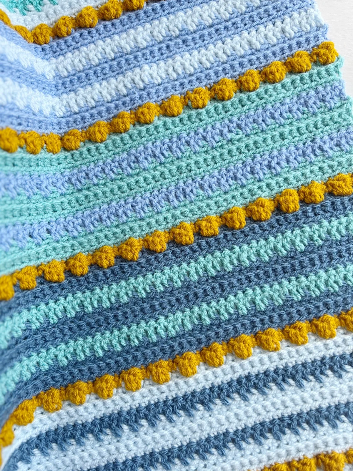 Crochet blanket with bobbles and bright modern colours.