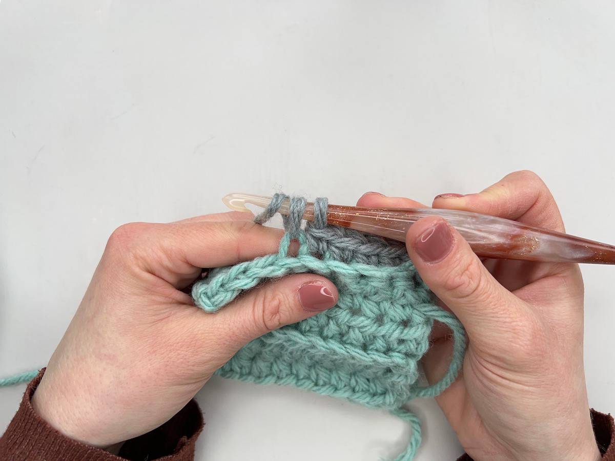 Single crochet blo being worked with grey yarn.