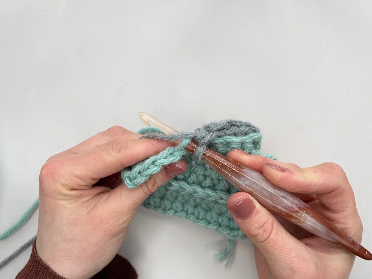 Crochet hook being inserted into the back loop only of a stitch.