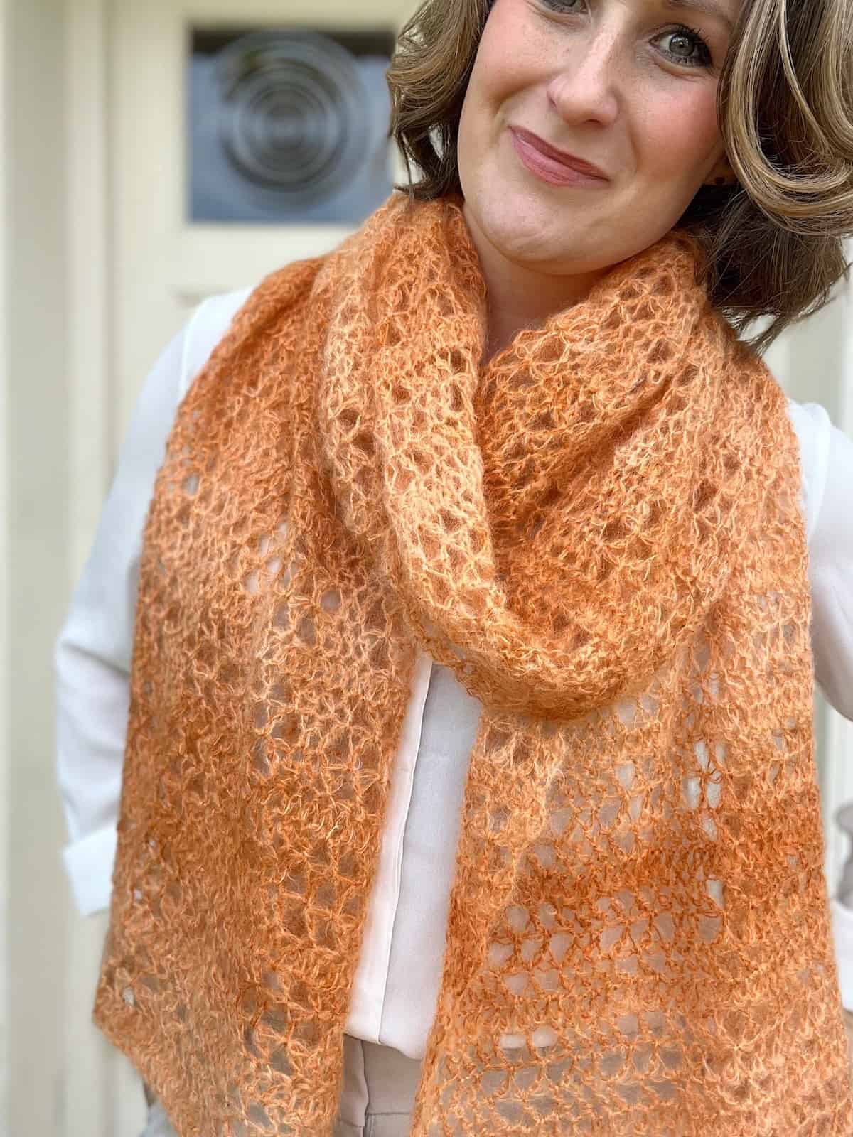 Summer crochet shawl pattern in orange mohair yarn.