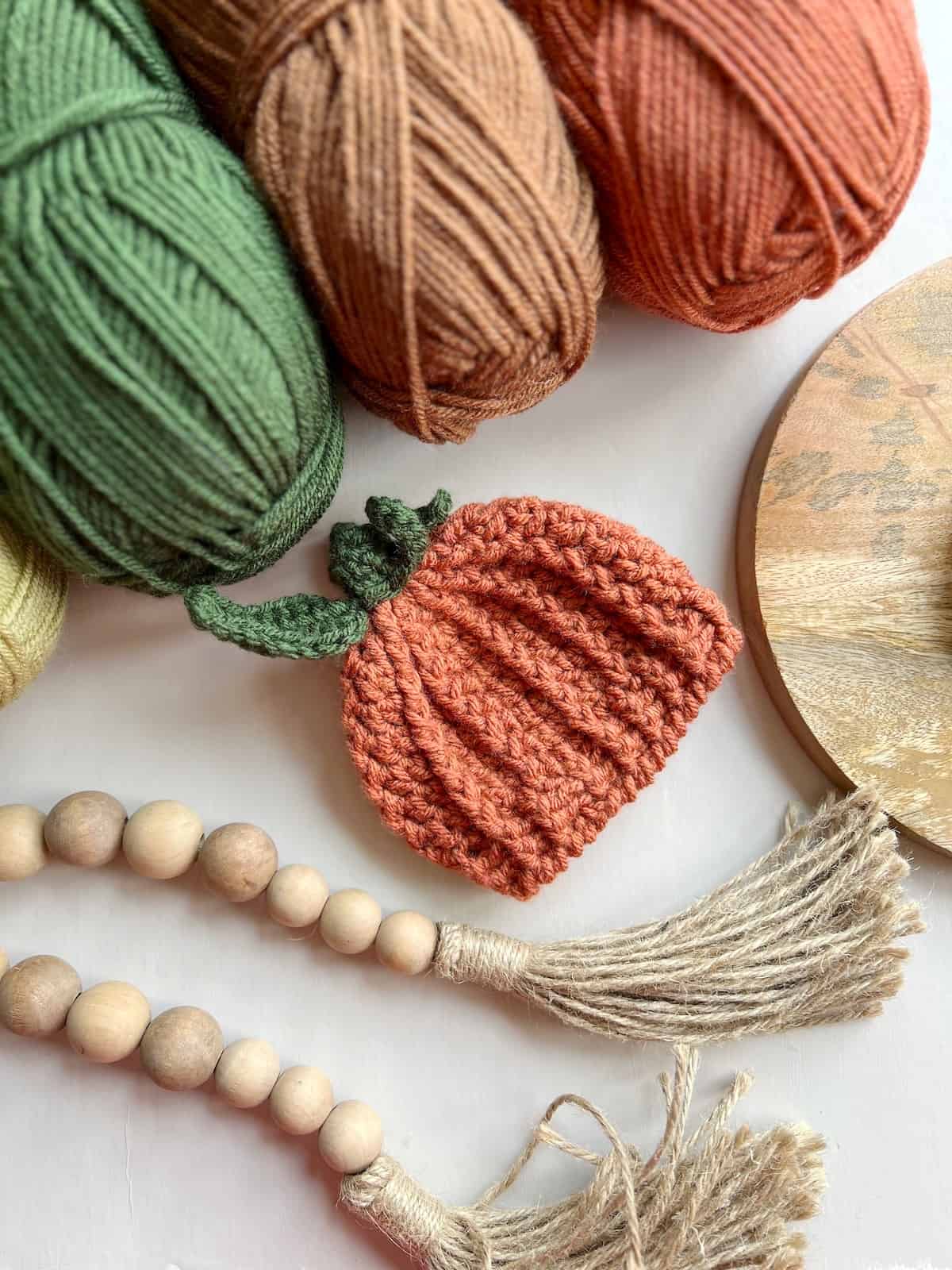 Cute crochet pumpkin hat with leaf and stalk on top.