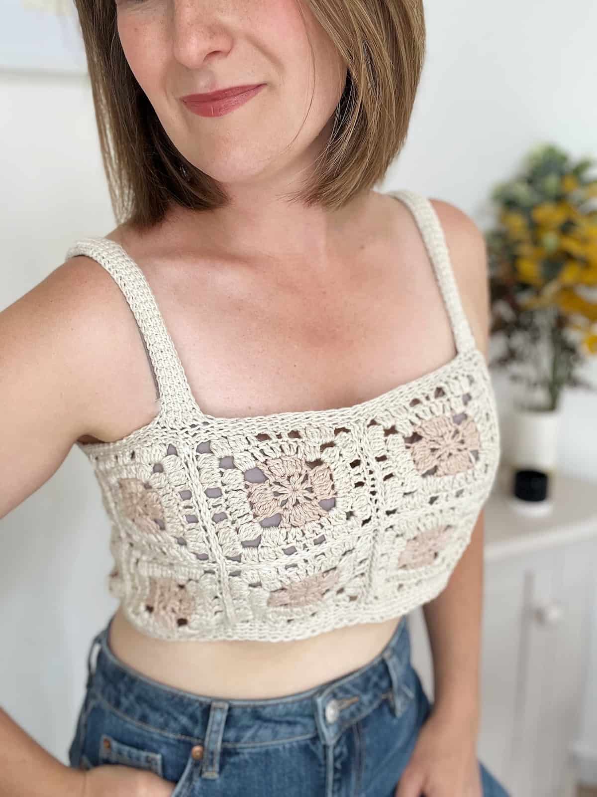 Woman wearing short crochet top made from granny squares.