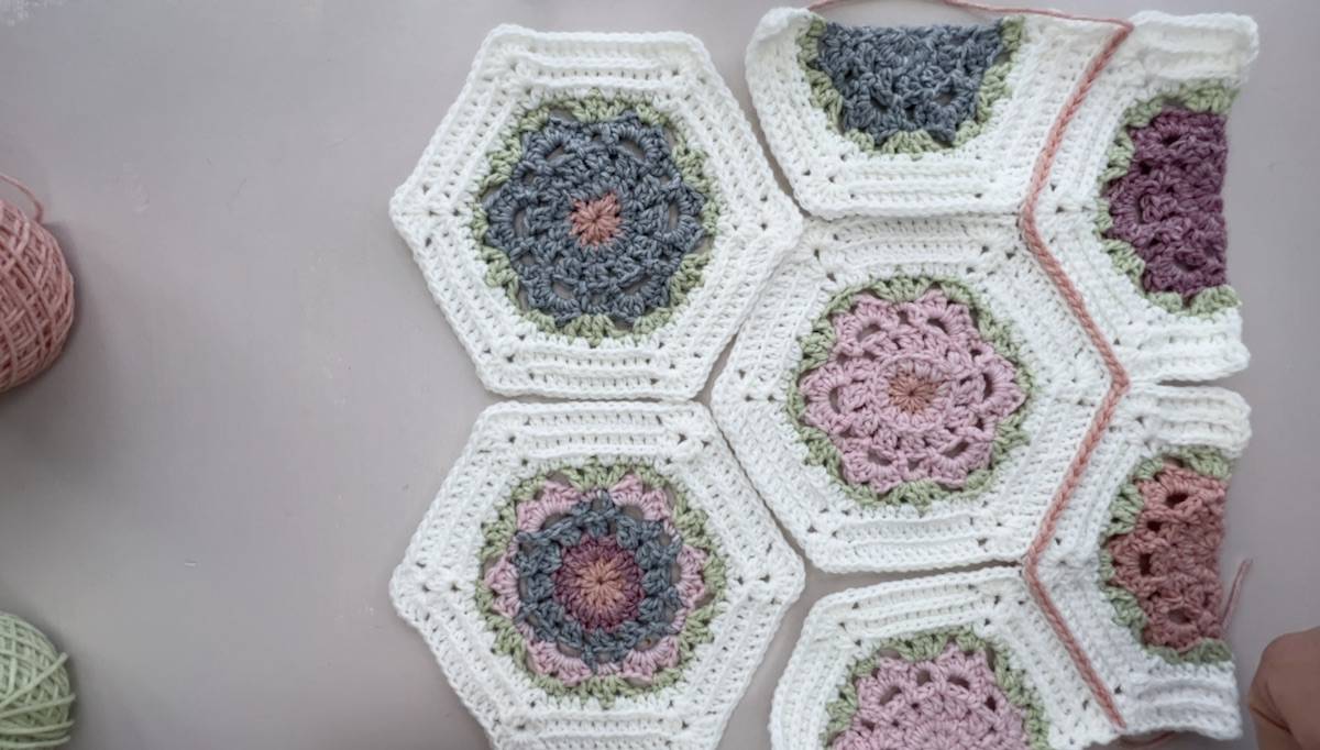 Crochet blanket with hexagons being joined together.