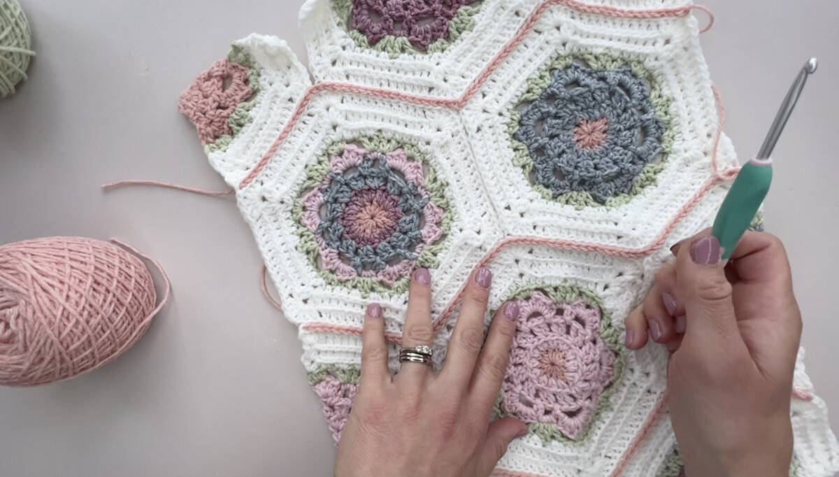 Vertical lines of a blanket crocheted together in hexagons.