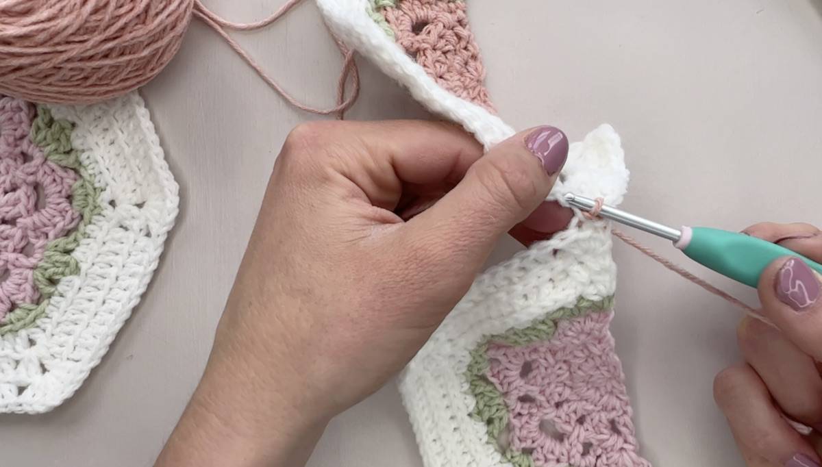 Image showing person working a flat slip stitch seam join for hexagons.