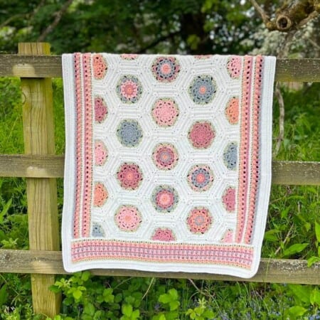 Time To Bloom crochet blanket on fence.