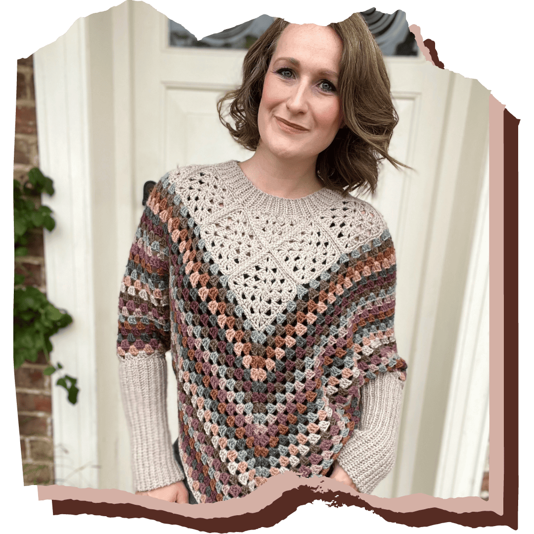 A woman wearing a crocheted poncho in front of a door.