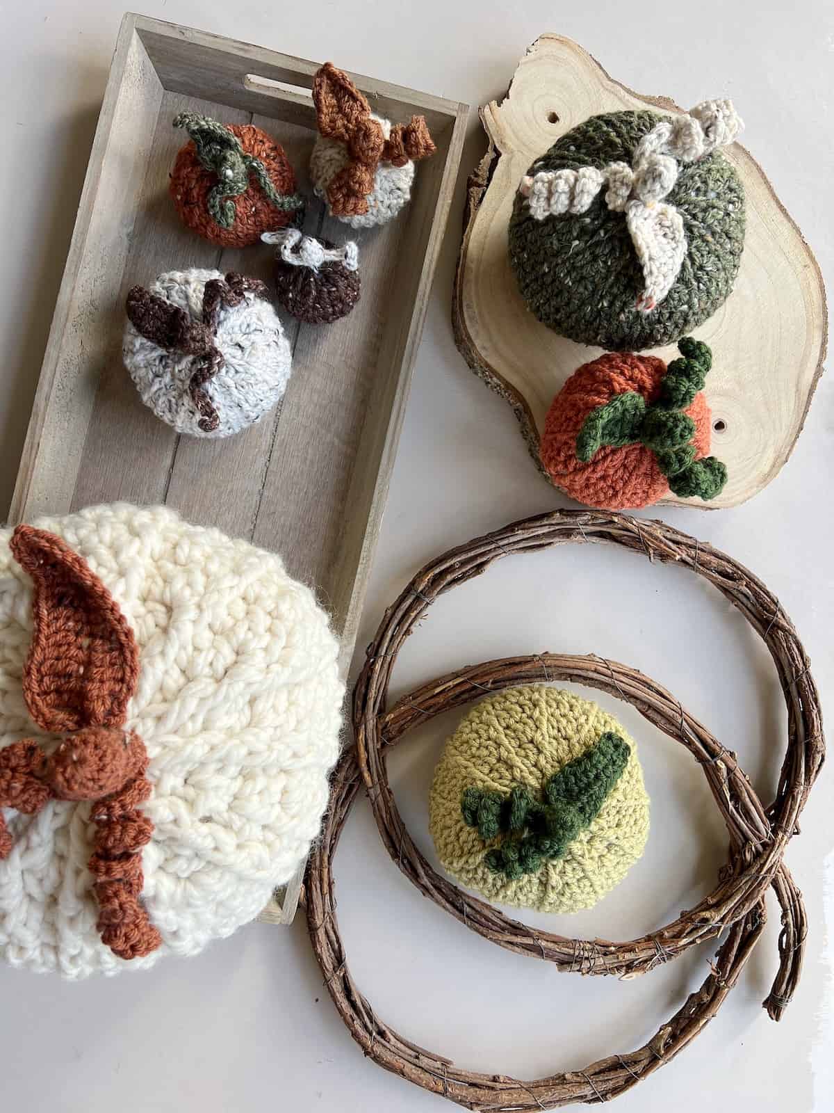 Crochet pumpkins on a wooden tray.