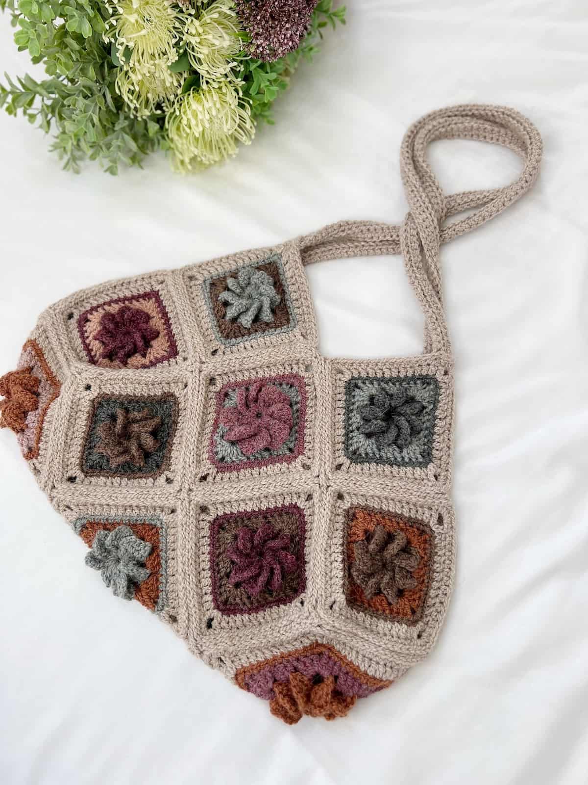 A crocheted bag with flowers on it.