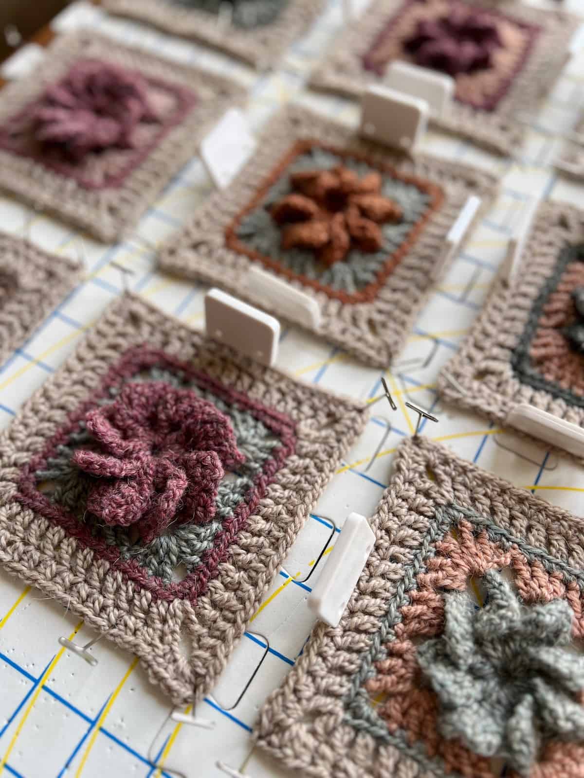 A group of crocheted squares on a table.