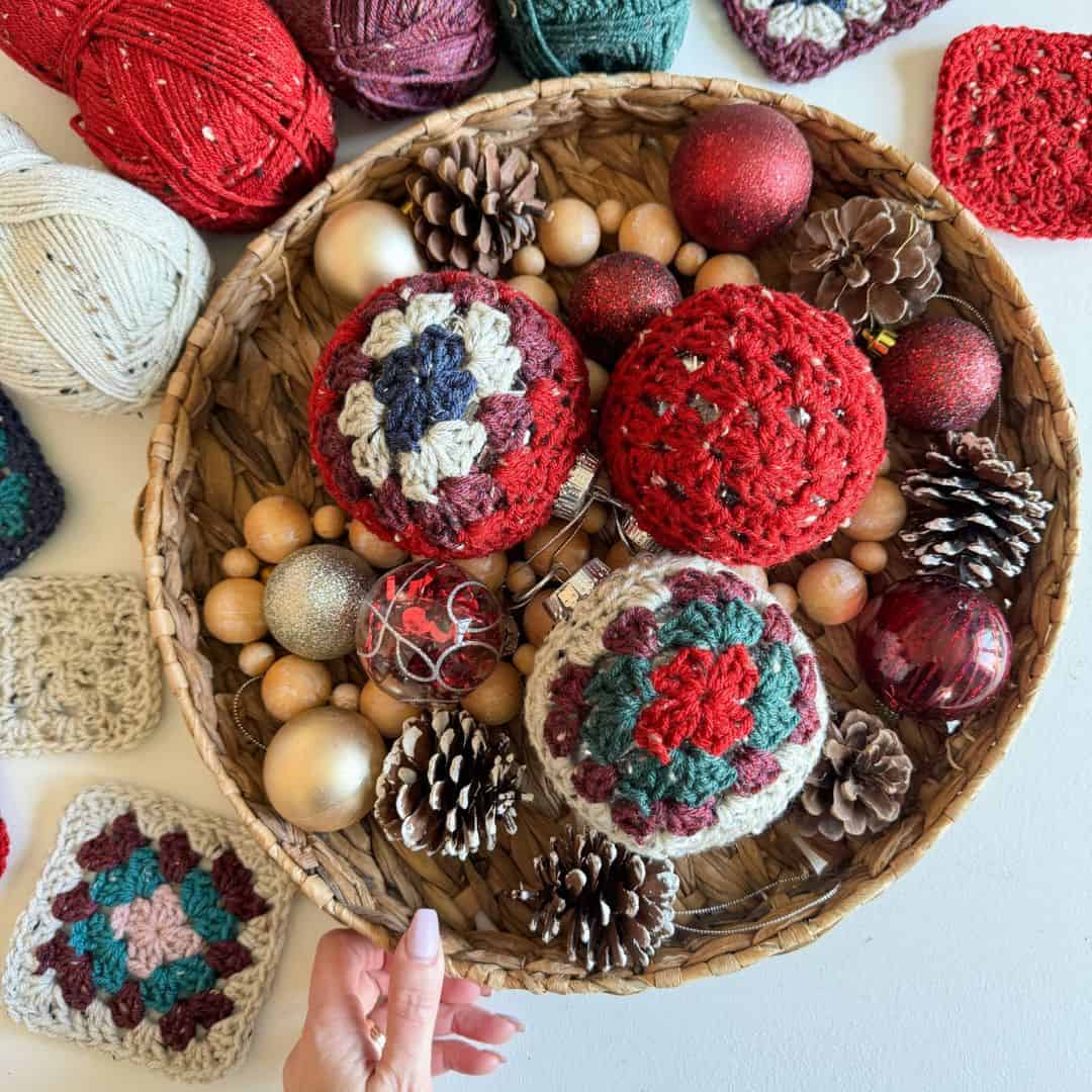 A basket full of crocheted balls and pine cones.