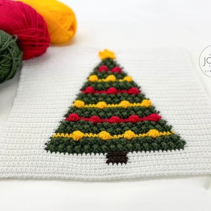 A crocheted christmas tree with yarn next to it.
