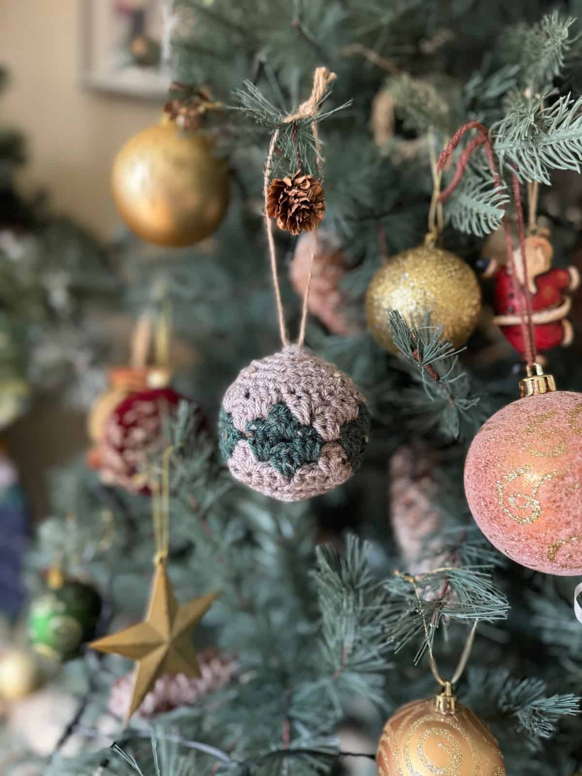 Crochet christmas ornaments hanging on a christmas tree.
