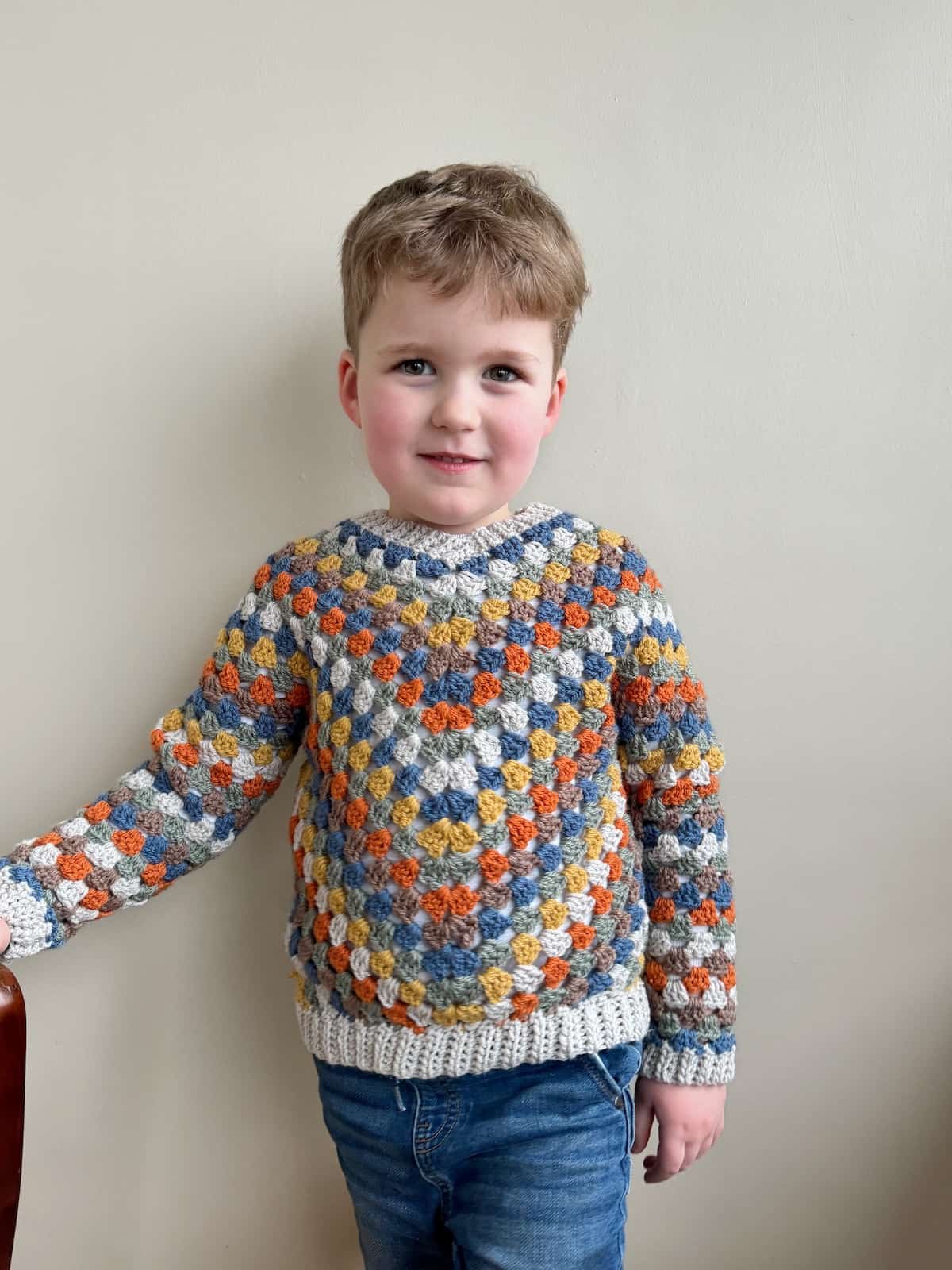 A child in a crocheted sweater.