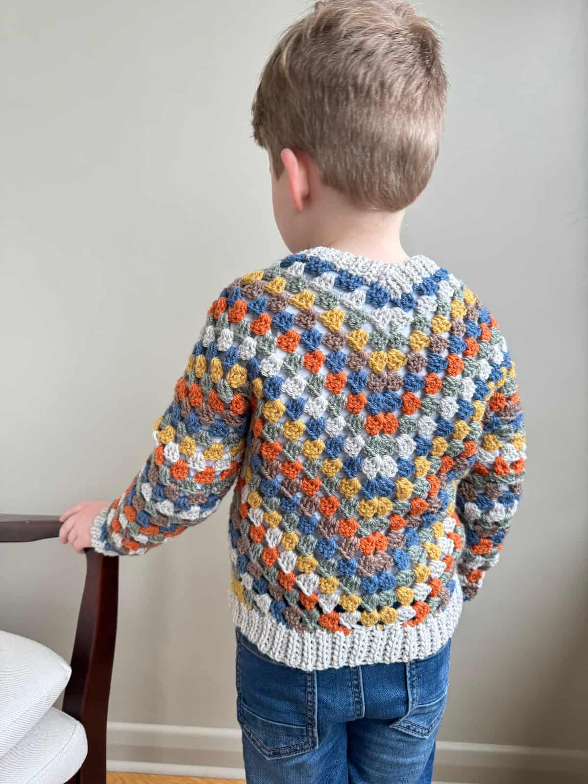A young child in a crocheted sweater.