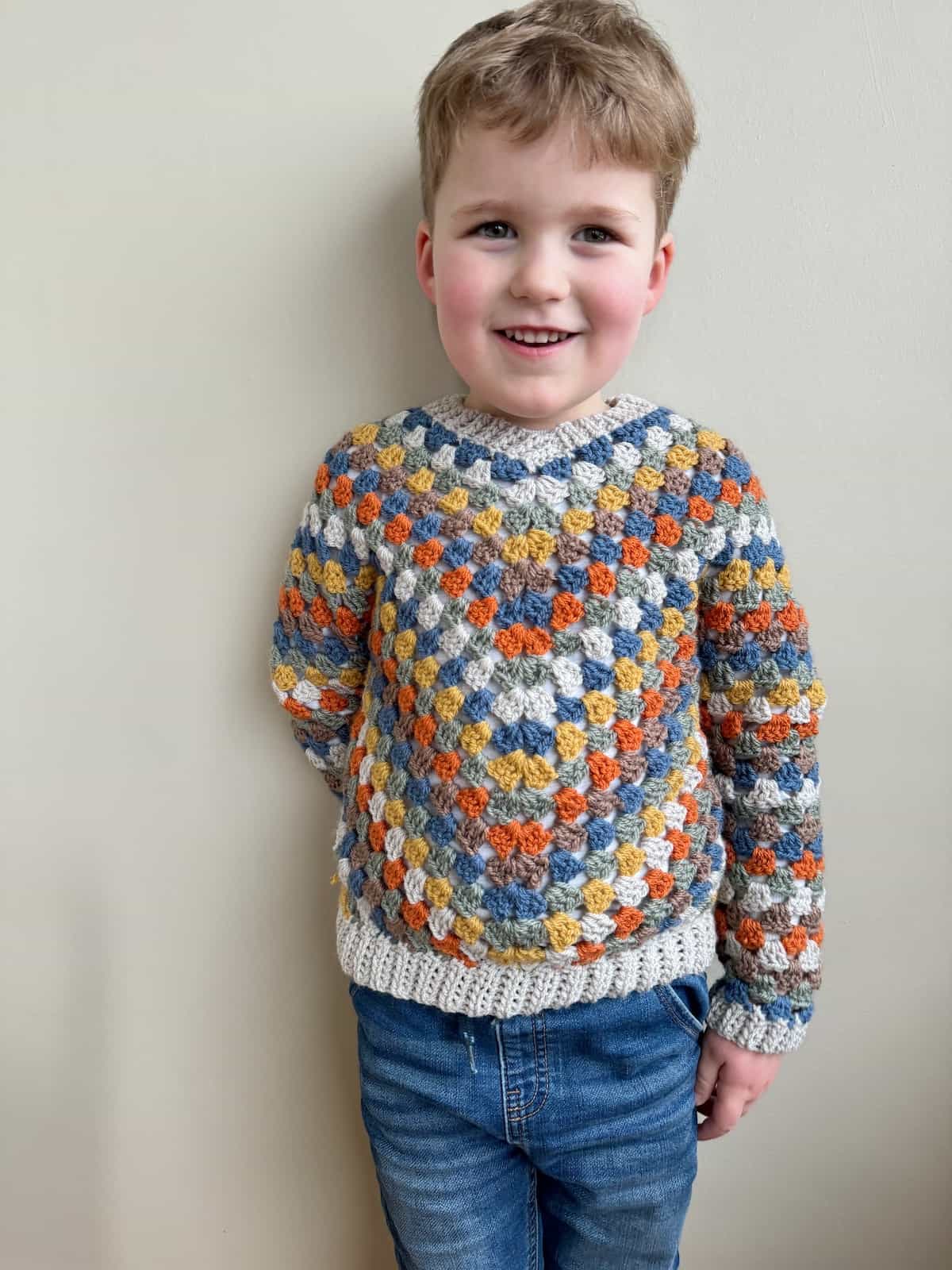 A young child in a crocheted sweater.