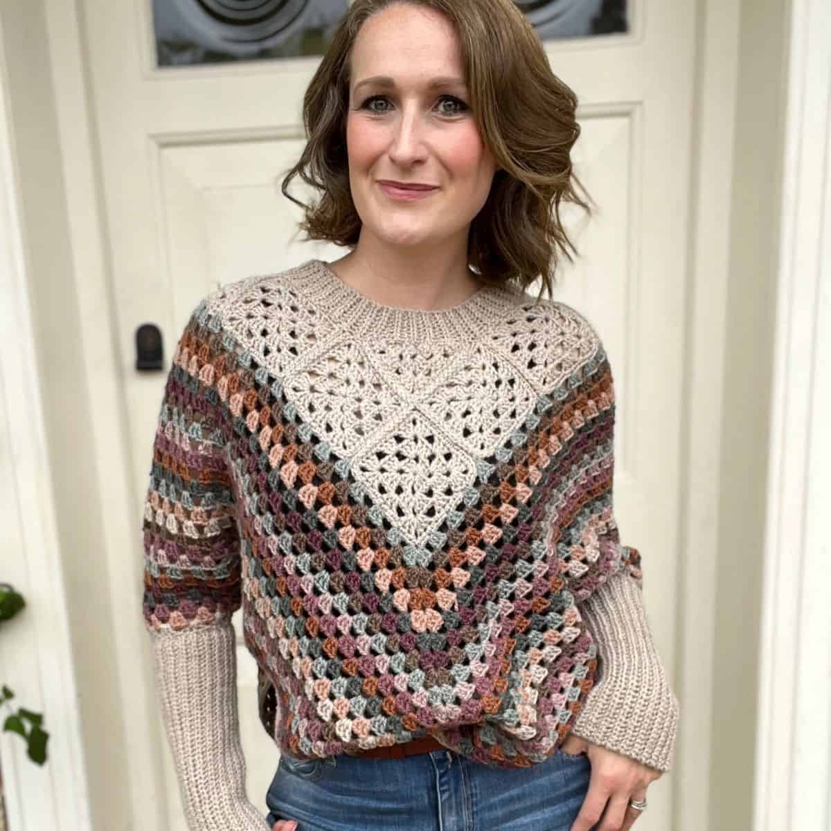 A woman wearing jeans and a crochet garment.