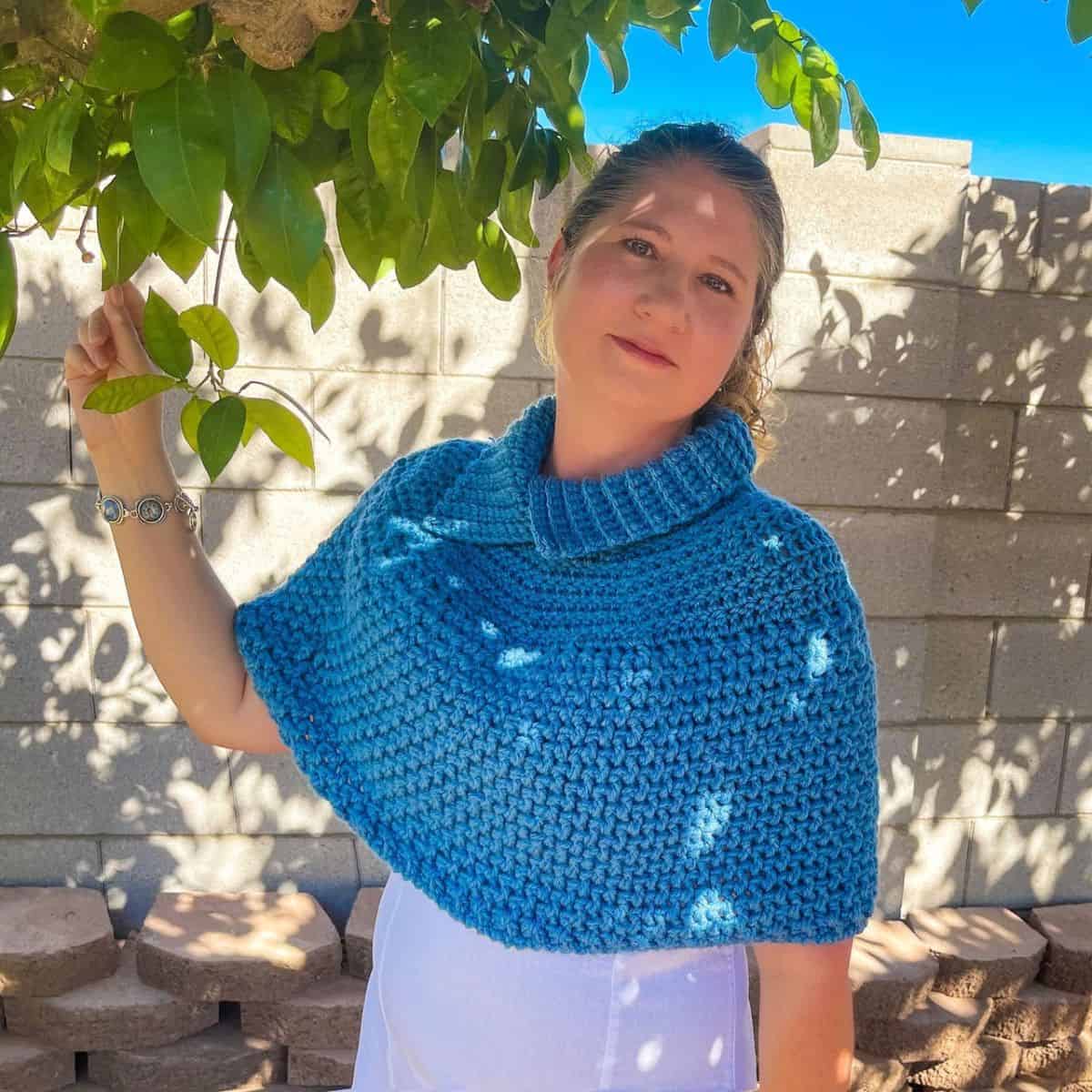 A woman wearing a blue crocheted garment.