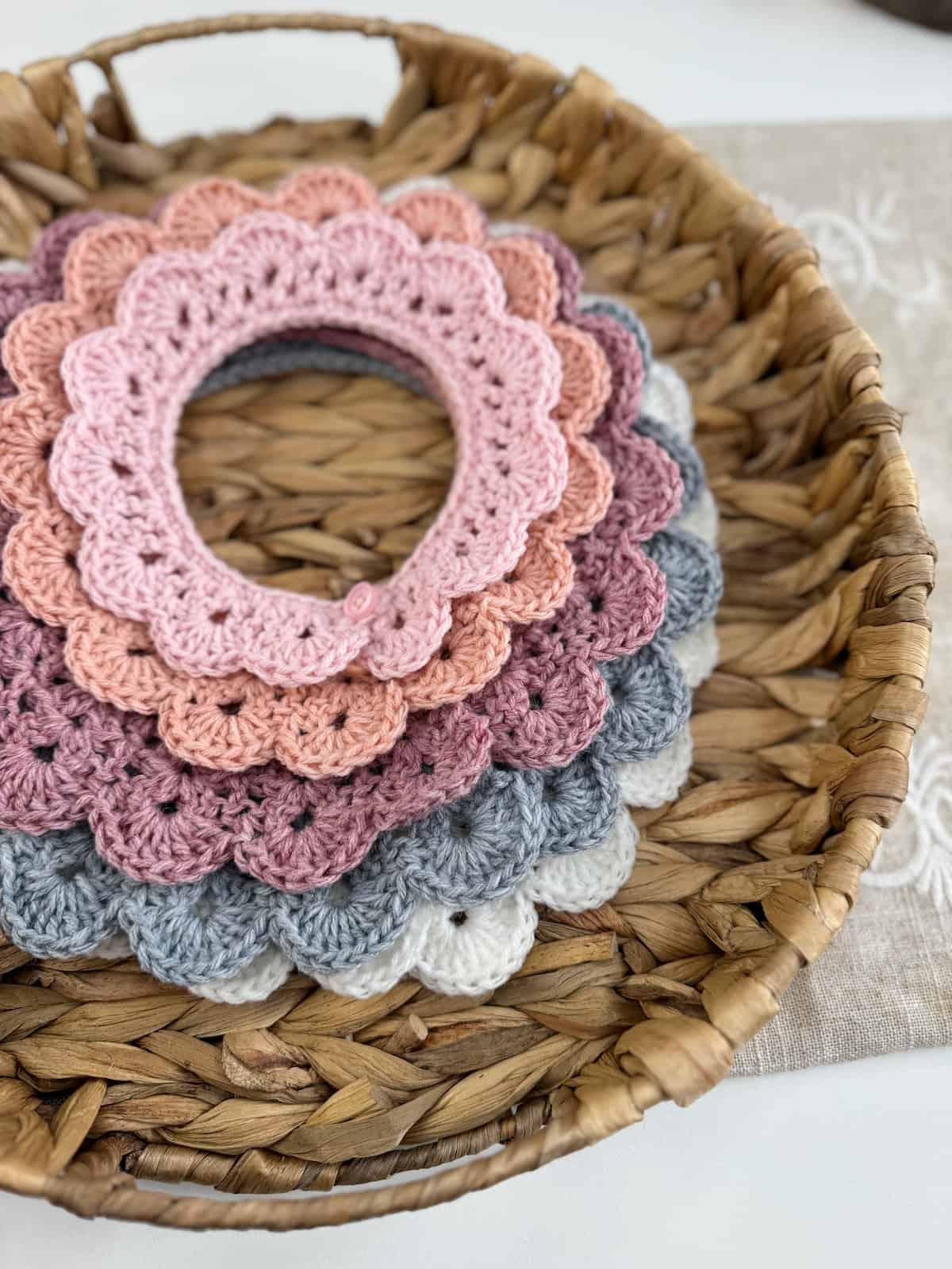 Pretty crocheted lace collars in a basket on a table.
