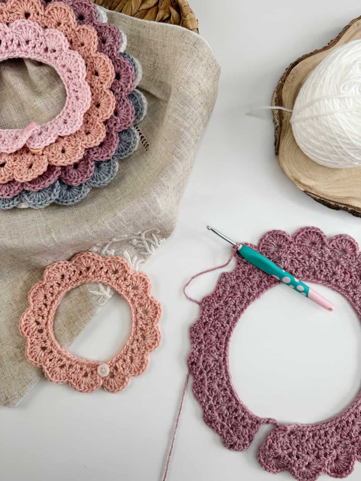 A crochet collar being made with a crochet hook and a yarn ball.