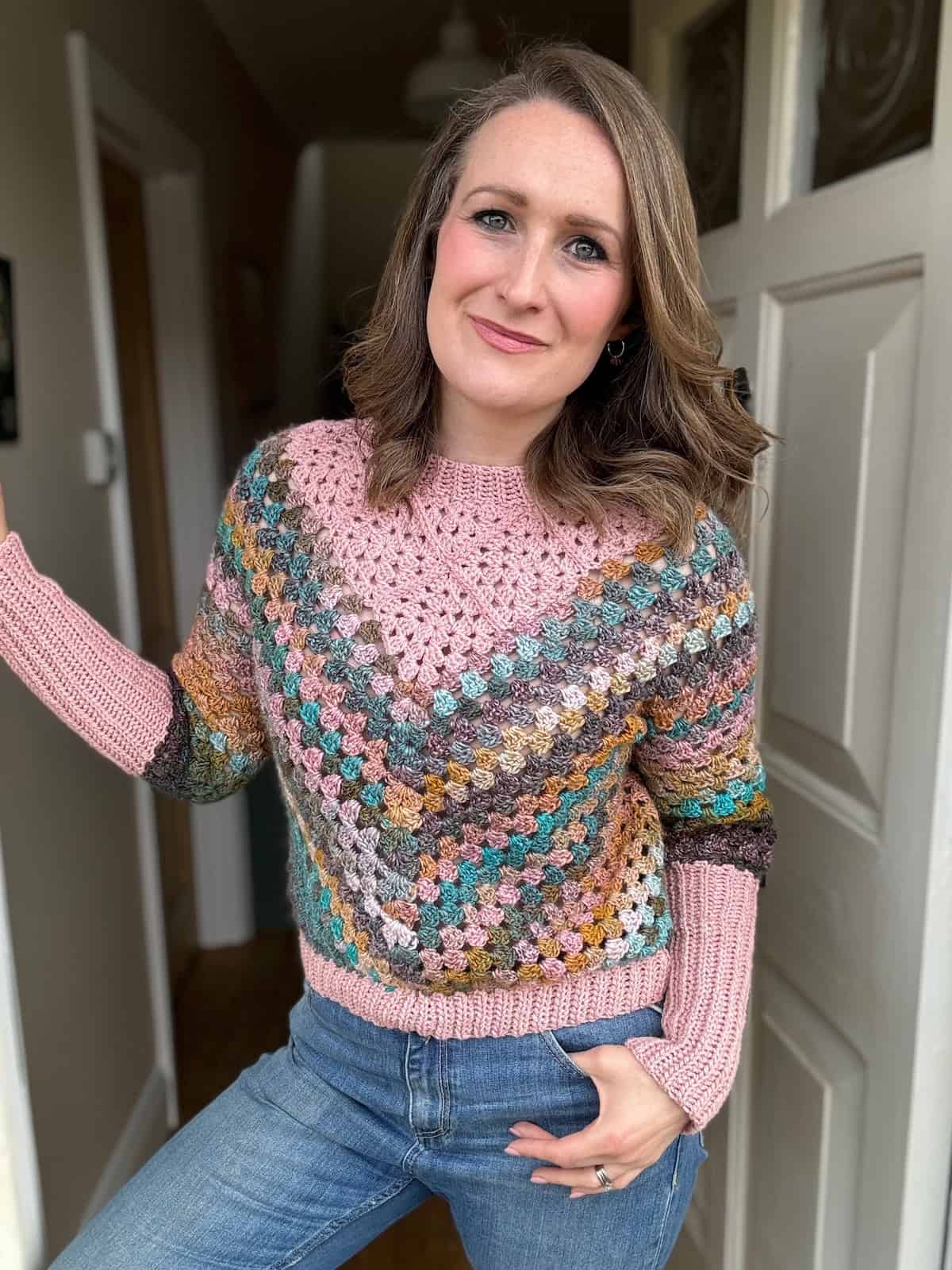 Woman in doorway wearing a modern crochet sweater.