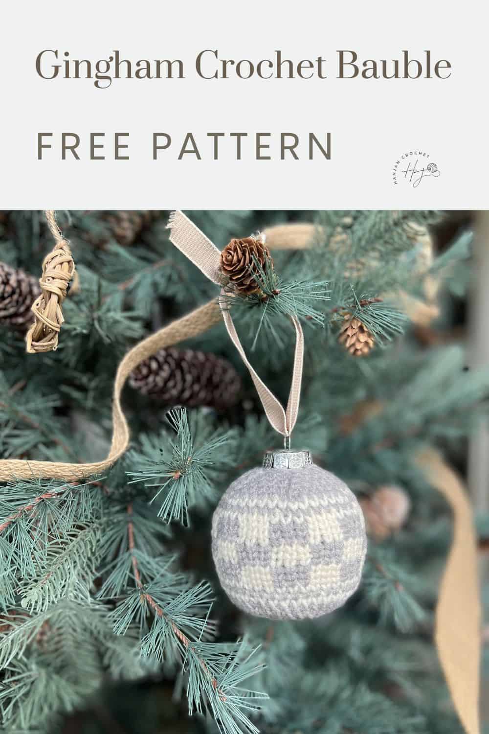 A grey and white gingham crochet bauble hangs on a Christmas tree. Text above reads "Gingham Crochet Bauble Pattern FREE.