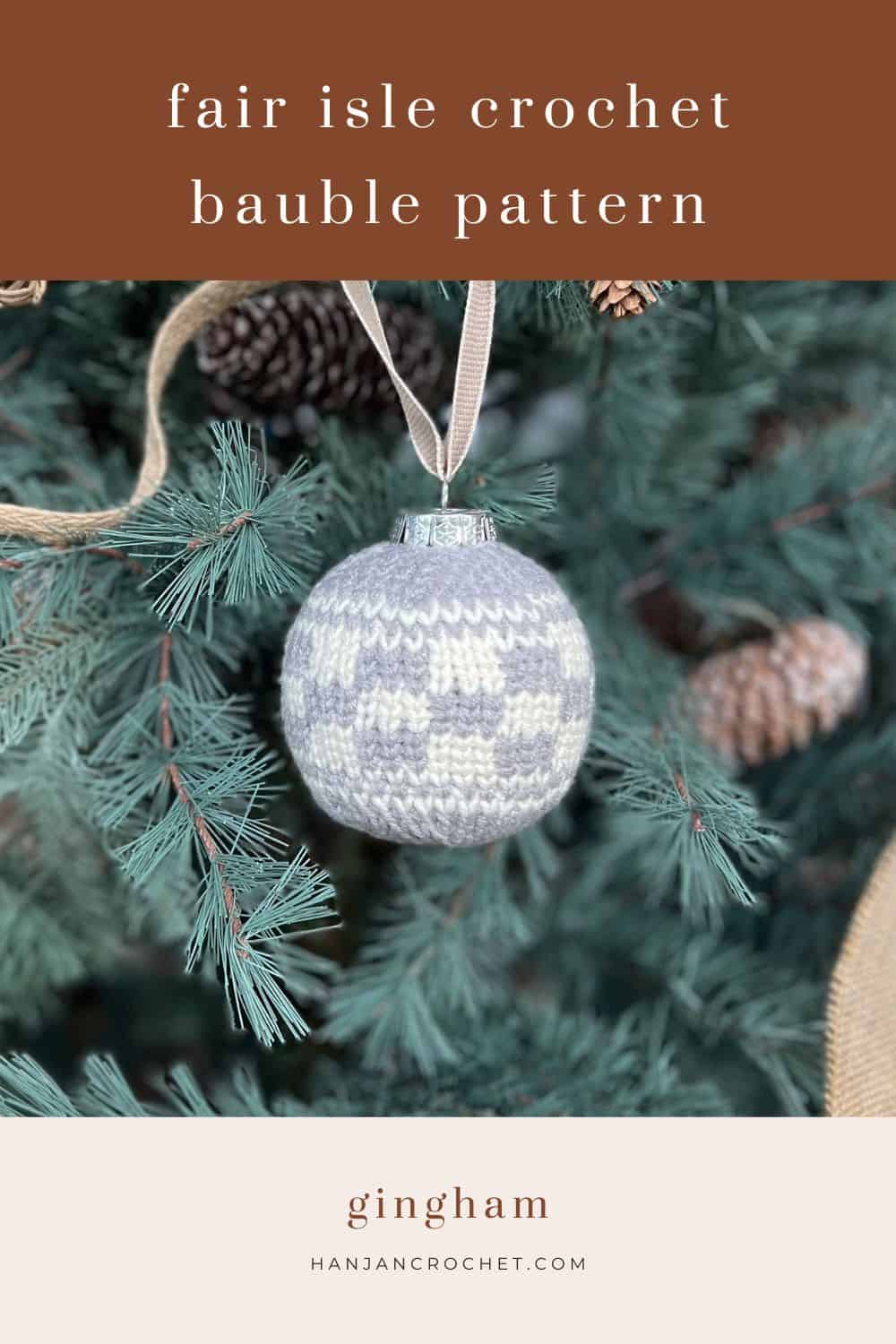 A gray and white gingham crochet bauble pattern hangs from a tree branch. Text on the image reads "fair isle crochet bauble pattern" at the top and "gingham, hanjancrochet.com" at the bottom.
