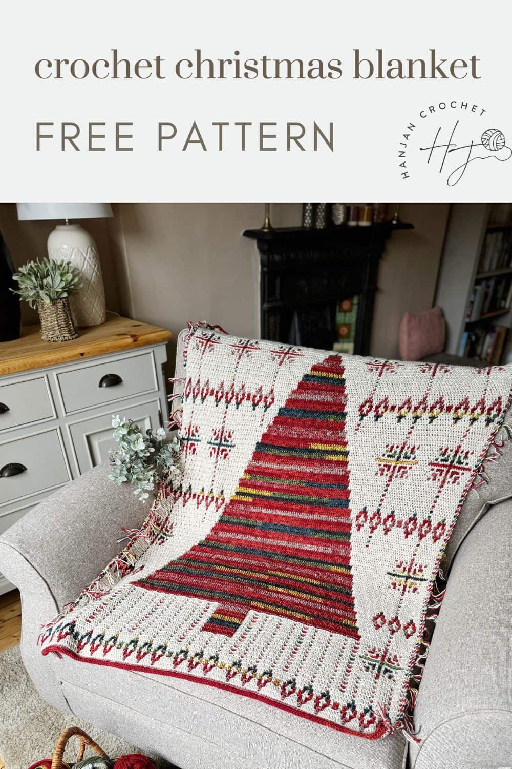 A cozy crochet Christmas blanket pattern with red and white designs is elegantly draped over a chair in the living room.
