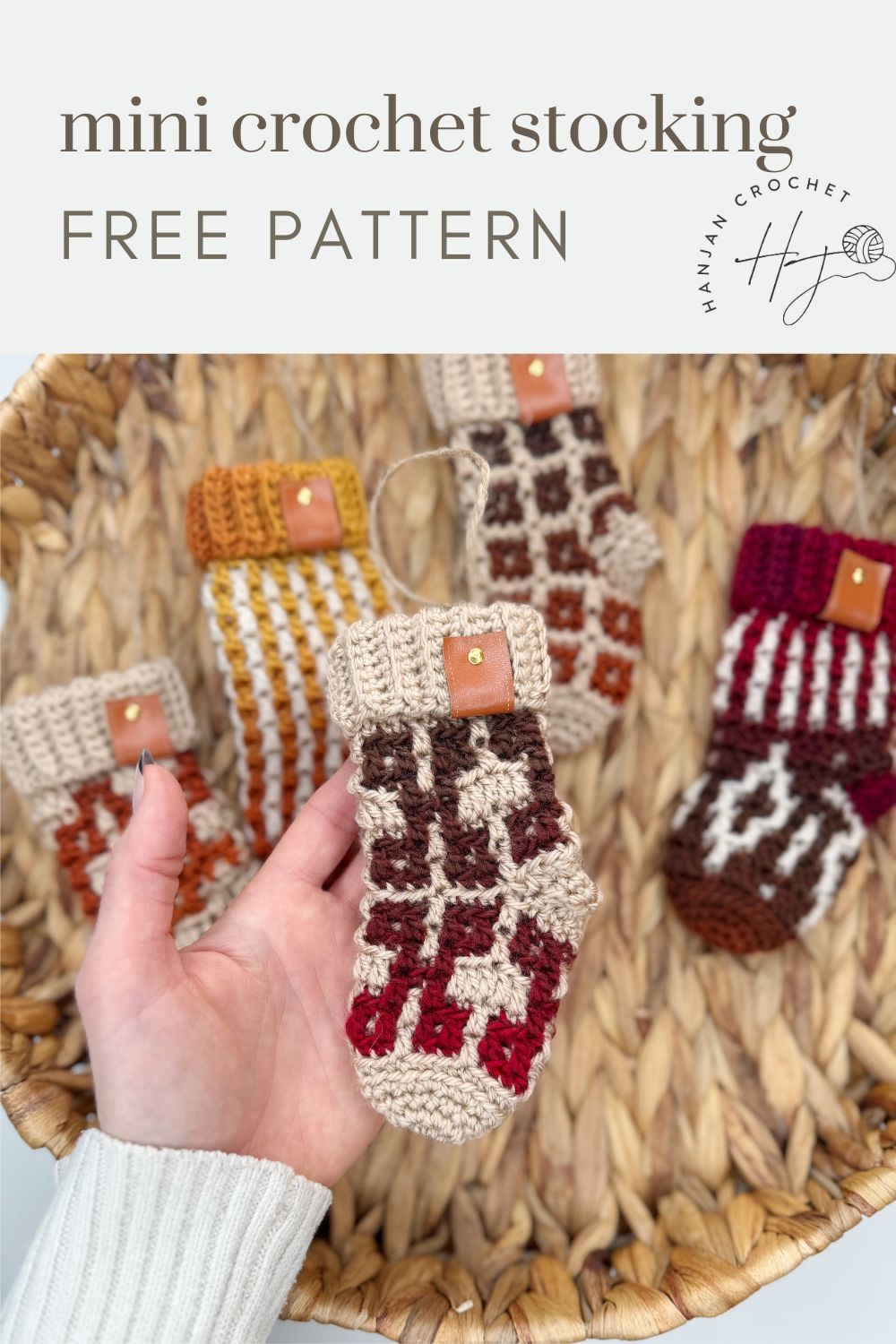 Hand holding a mini crochet christmas stocking in red, beige, and brown tones over a basket with four other colorful mini crochet stockings. Text reads "mini crochet stocking FREE PATTERN." Perfect for those looking for a festive mini crochet Christmas stocking pattern to add holiday charm to their décor.