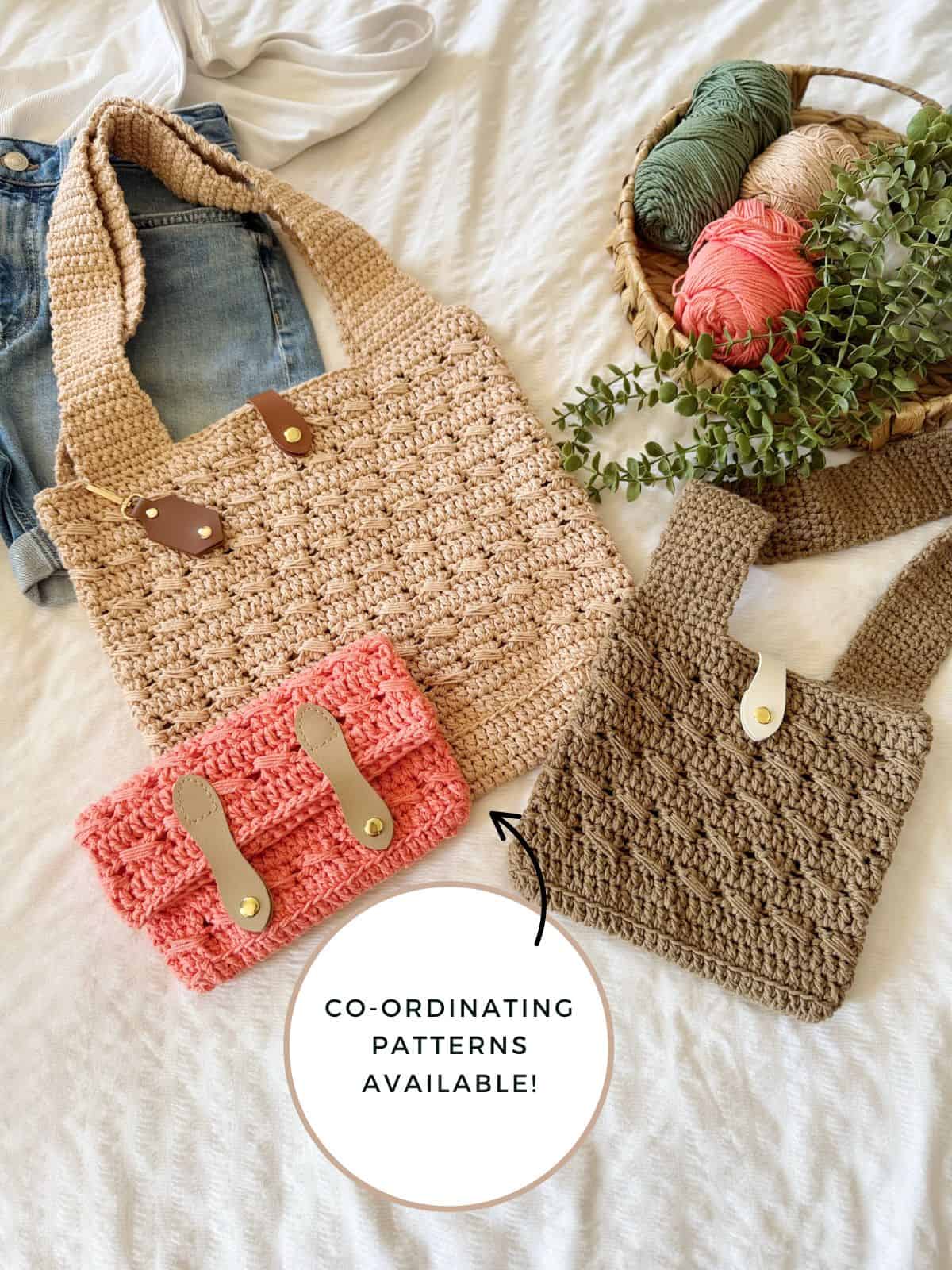 Three crocheted bags in beige, pink, and brown are displayed on a white surface with a basket of yarn, denim, and greenery. Text reads: "Crochet cross body bag free pattern—co-ordinating patterns available!.