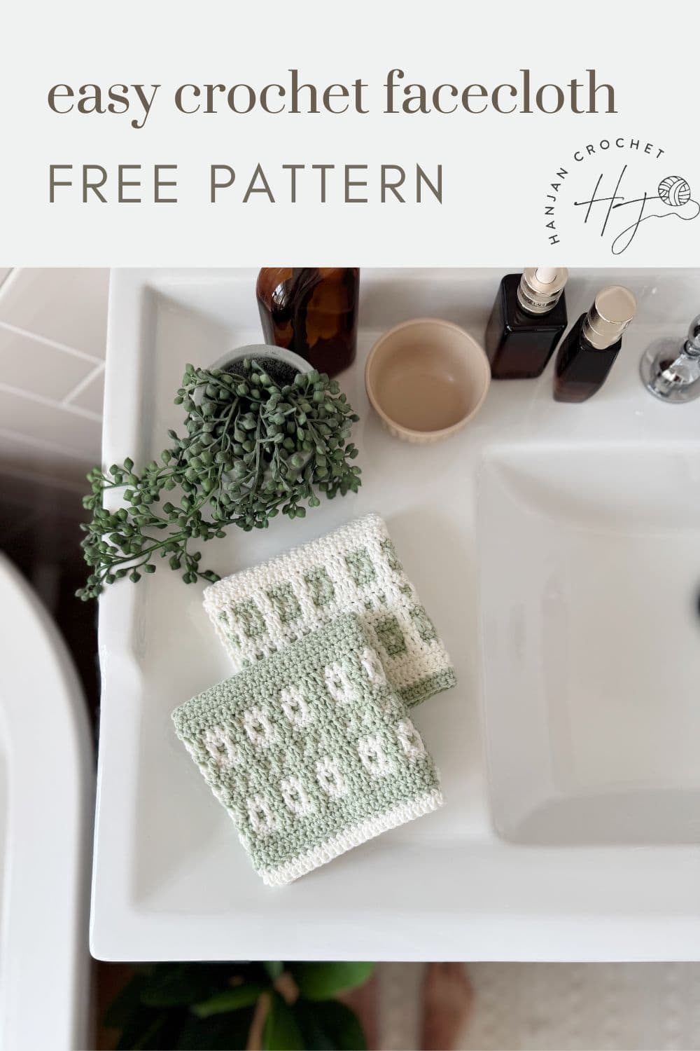 Two crocheted facecloths with a green and white mosaic crochet pattern are folded and placed on a white bathroom sink beside a potted plant and several bottles—a lovely touch inspired by a mosaic crochet free pattern.