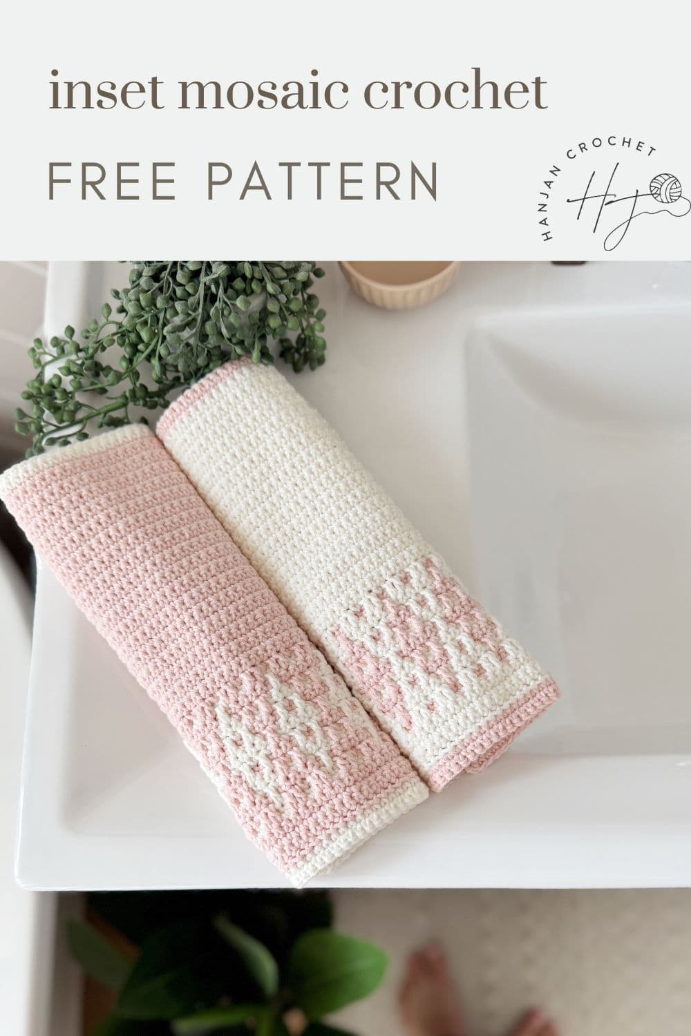 Two folded crochet hand towels with pink and white mosaic patterns, made using a Simple Mosaic Crochet Pattern, rest on a white bathroom counter near a sink and a green plant. Text reads: "inset mosaic crochet FREE PATTERN.