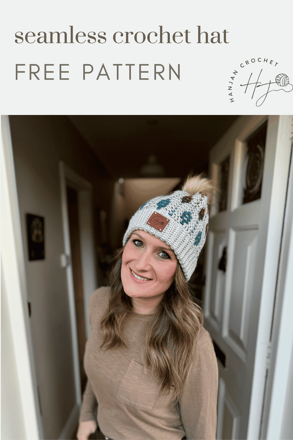 Woman wearing a beige and multicolored mosaic crochet beanie with a pom-pom, standing in a hallway. Text reads "seamless crochet hat FREE PATTERN.