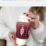 A person in a white sweater holds a to-go coffee cup wrapped in a red and white crocheted mosaic sleeve. Text reads "Crochet Coffee Sleeve Pattern—Mosaic Coffee Sleeve CROCHET PATTERN.