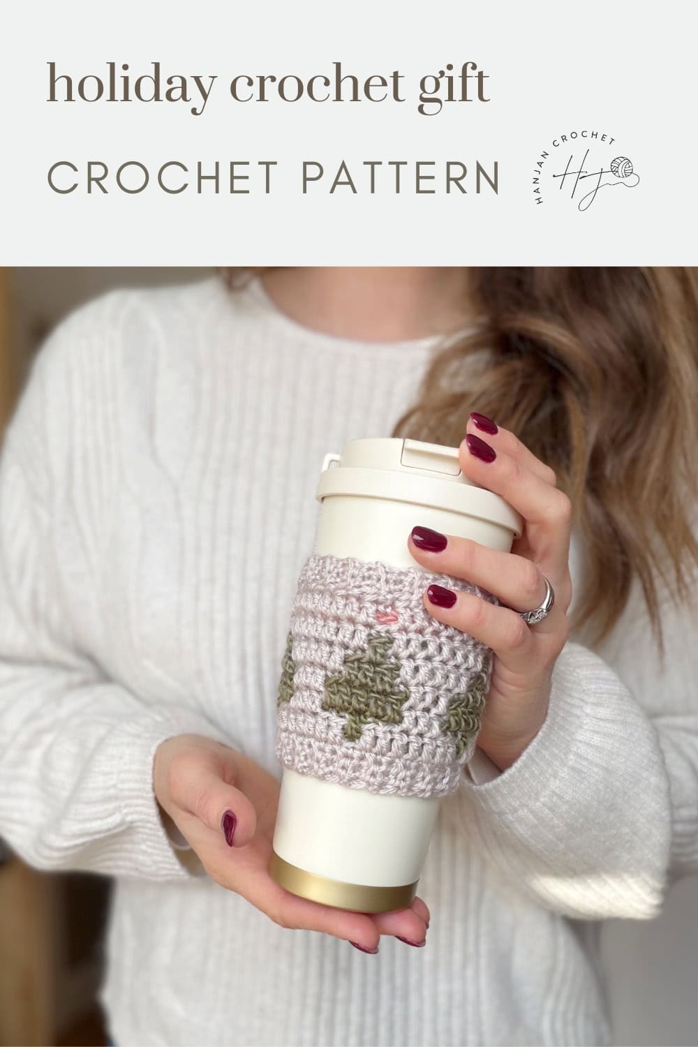 Woman in a white sweater holds a reusable coffee cup with a crocheted cozy featuring a green and beige pattern. Text reads "holiday crochet gift CROCHET PATTERN Crochet Coffee Sleeve Pattern.