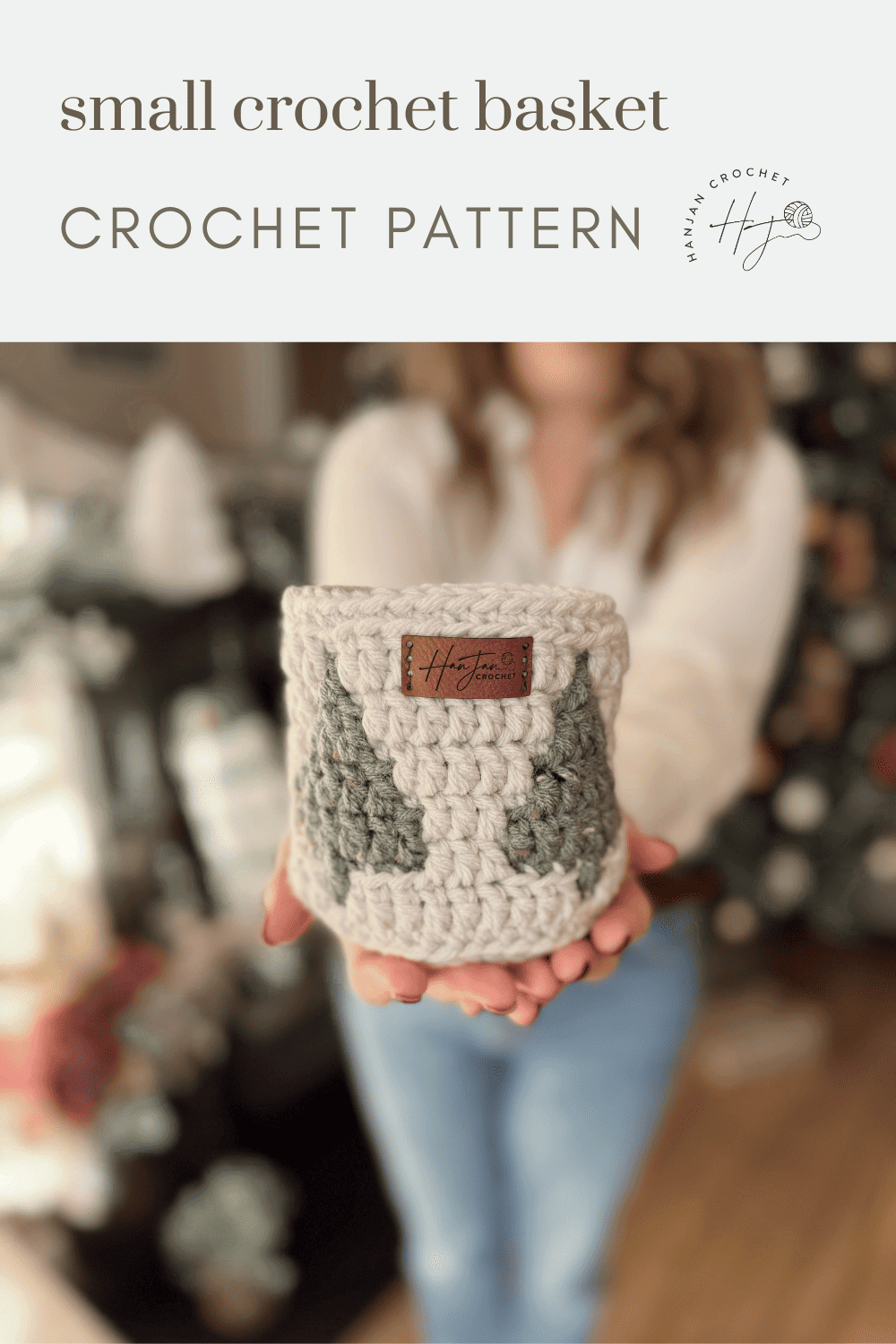 A person holds a small christmas crochet basket with a tree pattern and leather tag, in front of a blurred background with festive decor. Text reads "small crochet basket CROCHET PATTERN.