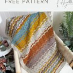 A multicolored, lacy crochet blanket with textured patterns draped over a chair, next to potted plants; text reads "gender neutral crochet blanket free pattern.