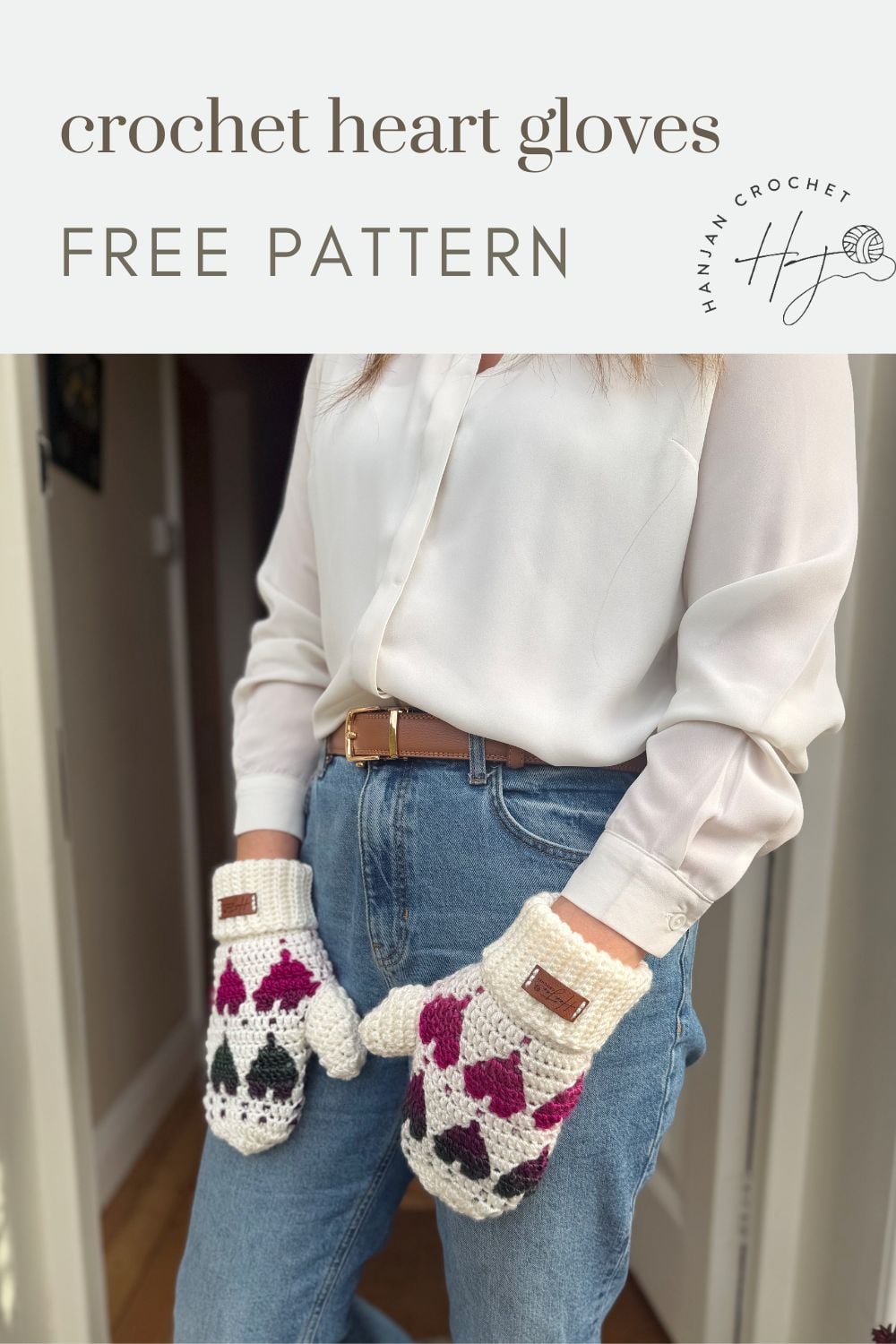 A person in blue jeans and a white shirt models crochet heart mittens—white with pink, red, and black heart patterns. Text reads "crochet heart gloves FREE PATTERN".