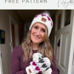 Woman wearing a white knit hat with a pom-pom and matching crochet heart mittens, standing indoors and smiling at the camera. Text reads "cute crochet mittens FREE PATTERN.