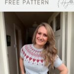 A woman stands in a hallway wearing a gray crochet sweater with a red heart pattern. Text above reads "heart crochet sweater FREE PATTERN" with a logo on the right.