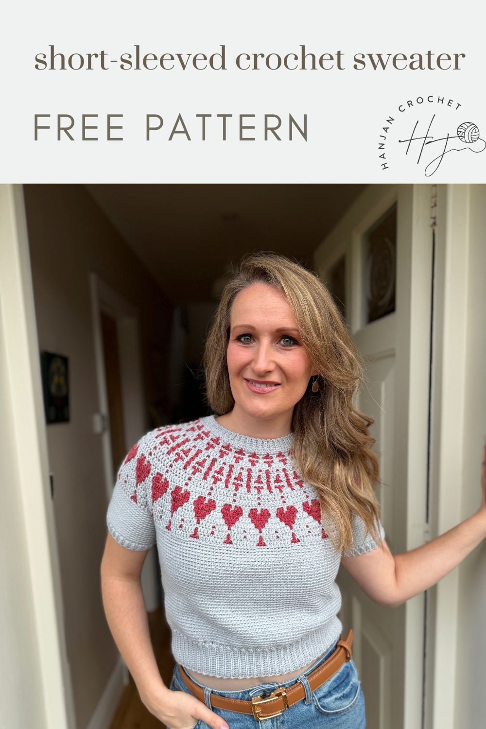 A woman stands in a hallway wearing a light gray, short-sleeved crochet sweater with a red and pink patterned yoke. Text above reads: "short-sleeved crochet sweater FREE PATTERN.